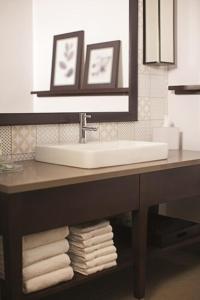 a bathroom with a sink and a pile of towels at Country Inn & Suites by Radisson, Springfield Southeast in Springfield