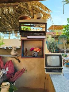 una televisione seduta su un muro accanto a un tavolo di Motel moon a Tunis