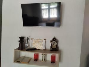 une étagère avec des bougies et une horloge sur un mur dans l'établissement Beautiful apartment in the Historic Center of Cartagena, à Carthagène des Indes