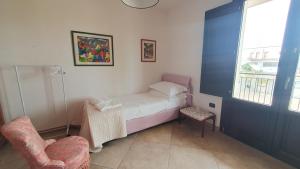 ein kleines Zimmer mit einem Bett und einem Stuhl in der Unterkunft La Bouganville in Mola di Bari