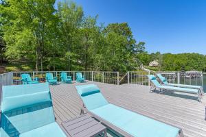 a deck with a bunch of blue lounge chairs at Lucky Dozen Lakehouse in Winchester