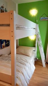 a white bunk bed in a room with a green wall at FEWO-Luik H-1-6 in Heiligenhafen +18 photos