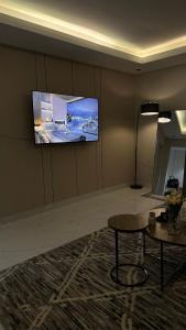 a room with a tv on a wall with a table at شقه لليله جميله ومريحه in Al Khobar +11 photos