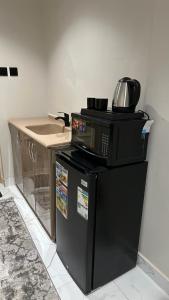 a microwave oven sitting on top of a refrigerator at شقه لليله جميله ومريحه in Al Khobar
