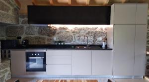 a kitchen with white cabinets and a sink at Casa do Oitão in Vieira do Minho +12 photos