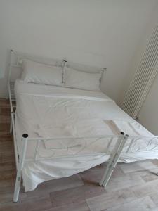 a white bed with white sheets and pillows at Via Battistelli Apartments in Bologna