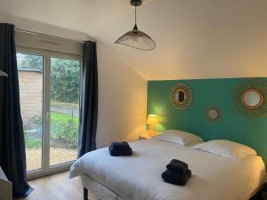 アルナージュにあるAux Premières Loges - Gîte de charme proche du circuitのベッドと大きな窓のある寝室