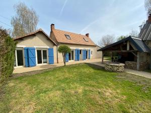 アルナージュにあるAux Premières Loges - Gîte de charme proche du circuitの青い扉と庭のある家