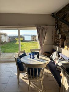 a table and chairs in a room with a window at High Tide Beach House on waters edge in Bangor