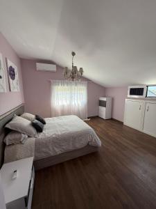 a bedroom with a bed and a chandelier at La casa amarilla in El Barraco