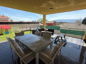 a wooden table and chairs on a balcony at La casa amarilla in El Barraco