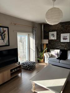 a living room with a couch and a tv at High Tide Beach House on waters edge in Bangor