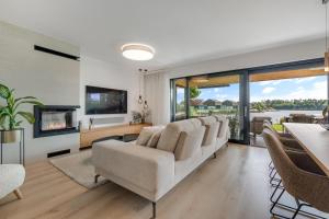 a living room with a couch and a tv at Lakeside Luxury Villa at Penati Golf Resort in Šajdíkove Humence