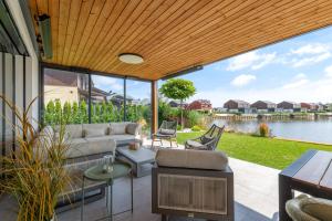 a living room with a view of the water at Lakeside Luxury Villa at Penati Golf Resort in Šajdíkove Humence