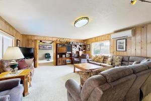 a living room with couches and a tv at Crescent Lake Lookout in Rockaway Beach