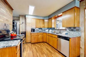 a large kitchen with wooden cabinets and appliances at Crescent Lake Lookout in Rockaway Beach +17 photos
