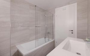 une salle de bain avec une douche, une baignoire et un lavabo dans l'établissement נופש משפחתי באילת עם נוף לים האדום, à Eilat 19 autres photos