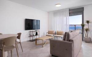 un salon avec un canapé et une table dans l'établissement נופש משפחתי באילת עם נוף לים האדום, à Eilat