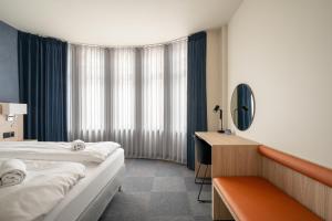 a hotel room with two beds and a desk at BREEZE Hotel Victoria - Self-Service in Bergen