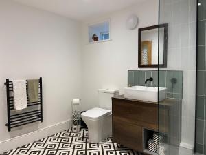 ein Badezimmer mit Toilette, Waschbecken und Spiegel in der Unterkunft Spacious Double Apartment in Folkestone with parking in Folkestone
