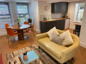 ein Wohnzimmer mit Couch und Tisch und eine Küche in der Unterkunft Spacious Double Apartment in Folkestone with parking in Folkestone + 10 Fotos