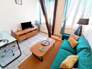 シャロン・アン・シャンパーニュにあるIdéal famille, proche gare et centre-ville, parking gratuitの緑のソファとテーブルのあるリビングルーム