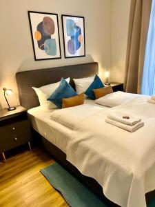 a bedroom with a large white bed with blue pillows at Cozy Voyage - Frauenkirche 1 - Zentral und ruhig in Dresden