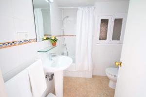 a white bathroom with a sink and a toilet at Hostal Los Pinos in Es Cana +38 photos