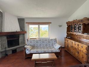 a living room with a couch and a window at Gold Cave casa vacanze relax nel bosco appartamenti in Pessinetto