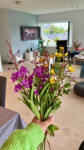 a vase filled with purple and yellow flowers on a table at LofotenApartmentOne in Stamsund +33 photos