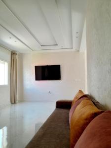 a living room with a couch and a tv on a wall at Villa Wilaya of Tétouan in Tetouan