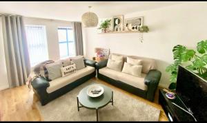 a living room with a couch and a table at Waterfoot Escape in Newcastle