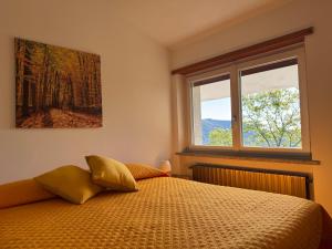 a bedroom with a bed and a window at Gold Cave casa vacanze relax nel bosco appartamenti in Pessinetto