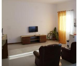 a living room with a tv and a couch at T1 conforto in Praia