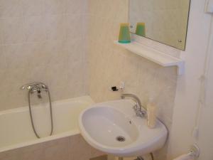 ein Badezimmer mit einem Waschbecken und einer Badewanne mit einem Spiegel in der Unterkunft Apartment Marija in Brbinj