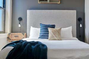 a bedroom with a white bed with blue walls at Furnished Luxury Loft Boston Common in Boston