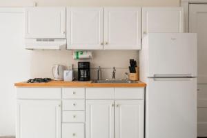 a white kitchen with white cabinets and a sink at Charming 1 Bedroom Newbury Street in Boston