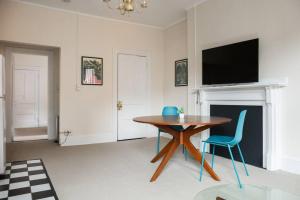 a living room with a table and chairs and a tv at Charming 1 Bedroom Newbury Street in Boston +1 photo