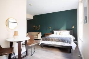 a bedroom with a bed and a green wall at Prime Boston Fidi L Shaped Studio in Boston