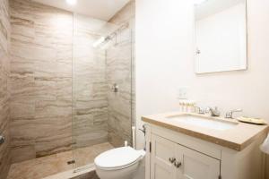 a bathroom with a shower and a toilet and a sink at Prime Boston Fidi L Shaped Studio in Boston
