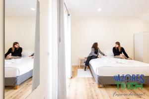 zwei Frauen auf Betten in einem Zimmer in der Unterkunft Hostel Casa São Pedro in Angra do Heroísmo