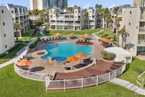 サウス・パドレ・アイランドにあるBahia Mar 160 Sun and Sand Escapeのパラソル付きのスイミングプールのオーバーヘッドビュー