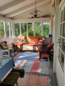 a screened in porch with a couch and chairs at Villa Lahtela in Kajaani +25 photos