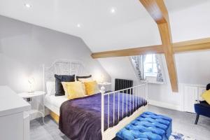 a bedroom with a bed with yellow and blue pillows at Martineau House - North East Escapes in Tynemouth