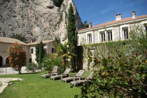 a group of chairs sitting in a yard next to a building at Auberge Du Parc in Orgon