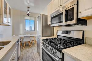 una cocina con estufa y microondas en Long Beach Panorama, en Long Beach 23 fotos más