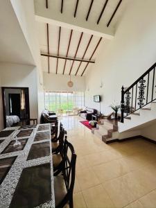 a living room with a table and chairs and a couch at Tranquil Garden Nuwara Eliya in Nuwara Eliya