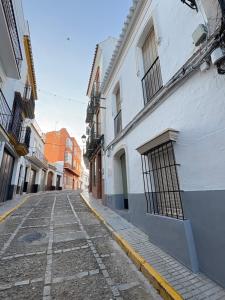 an empty street in an alley with buildings at La Clara Domus in Seville