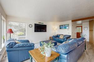 a living room with two blue couches and a table at Beach Time Getaway in Lincoln City