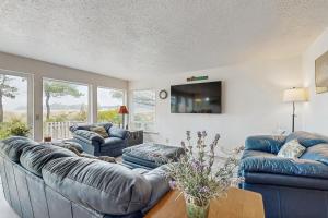 a living room with two couches and a tv at Beach Time Getaway in Lincoln City